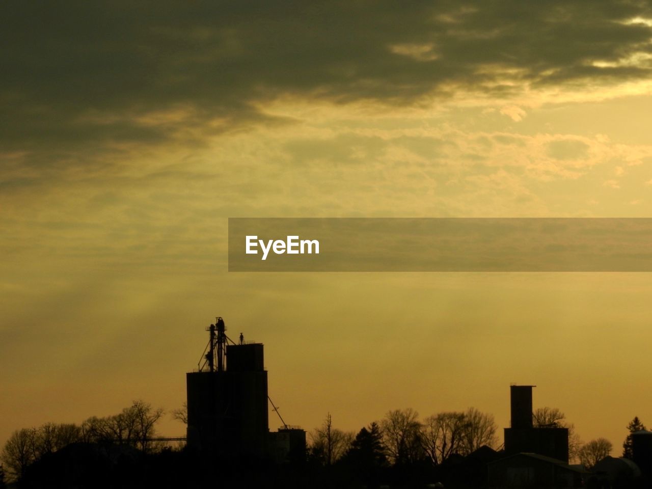 Low angle view of silhouette building against sunset sky