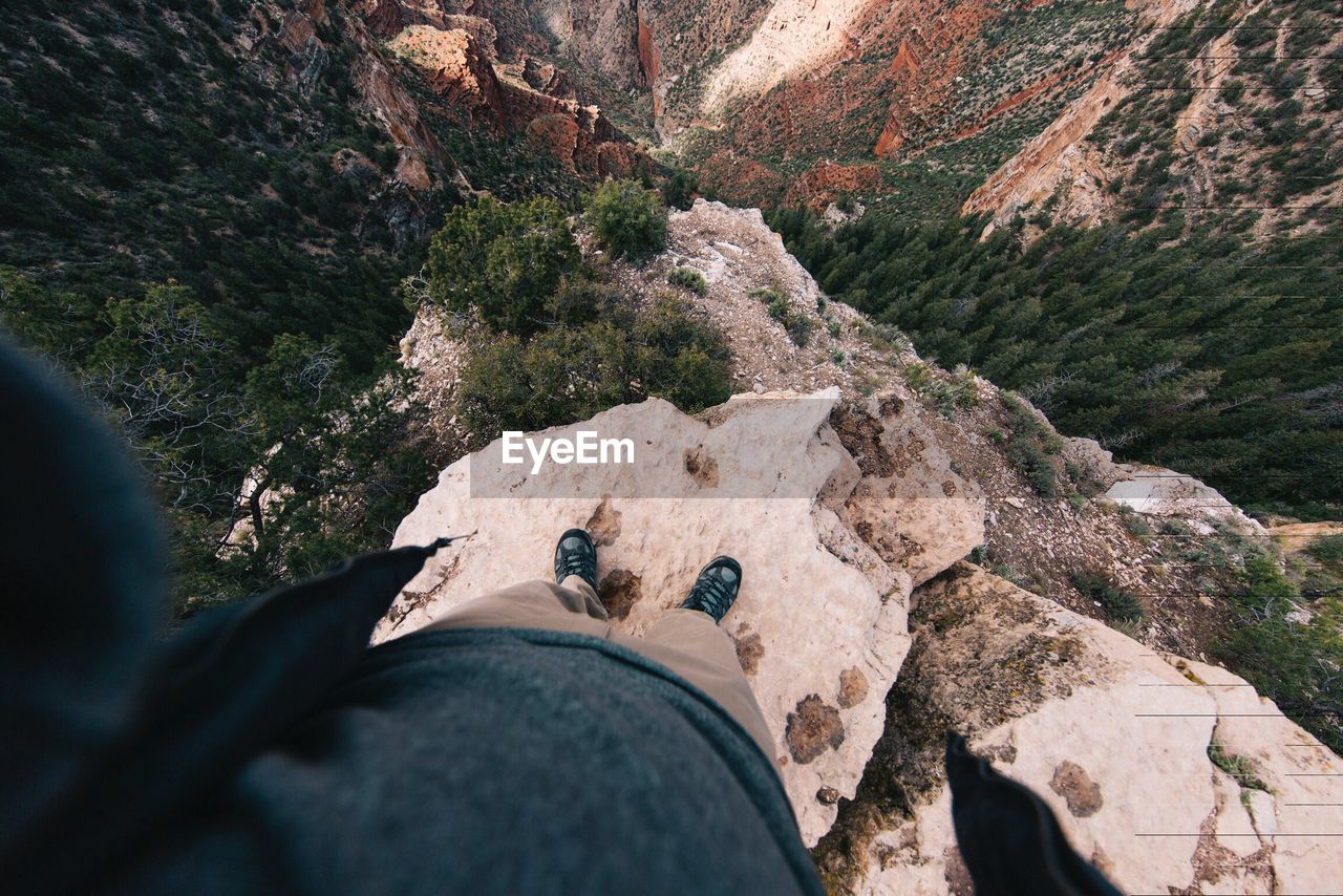 Low section of man on rock by mountain