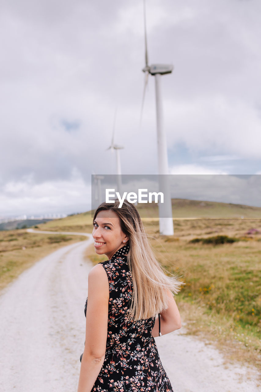 Beautiful woman standing on land against sky