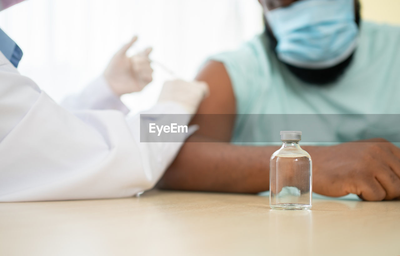 African american wear a medical mask and being covid vaccinated for the prevention of coronavirus