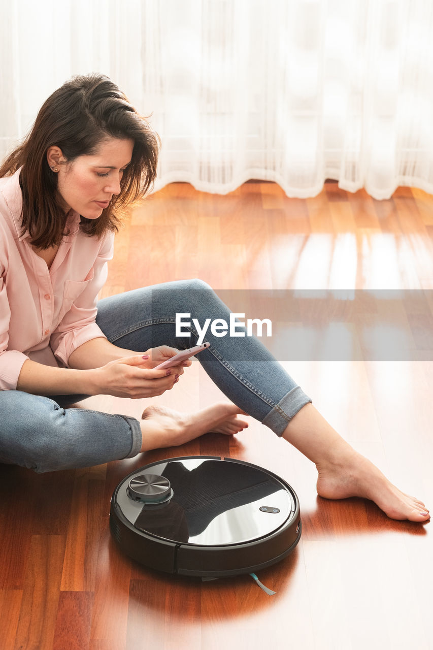 Young woman sitting on floor at home