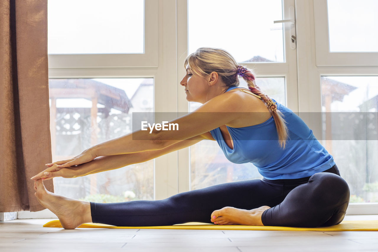 side view of young woman exercising in gym