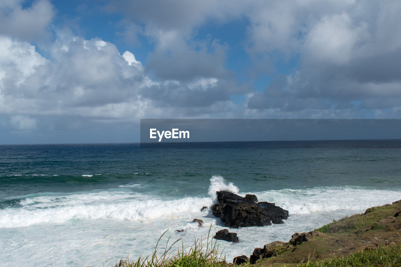sea, water, sky, land, beach, cloud, body of water, horizon, shore, ocean, horizon over water, beauty in nature, scenics - nature, wave, nature, coast, wind wave, rock, motion, environment, coastline, surfing, travel destinations, cliff, water sports, sports, outdoors, travel, tranquility, day, landscape, seascape, storm, vacation, tourism, bay, tranquil scene, cloudscape, idyllic, water's edge, non-urban scene, overcast, trip, holiday, urban skyline, terrain, sand, cove, grass