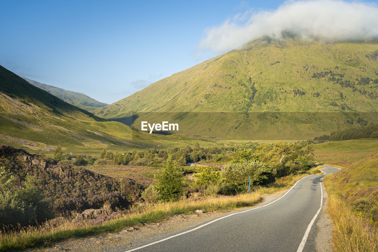 Scenic view of a hill and country single track road in glencoe, scotland