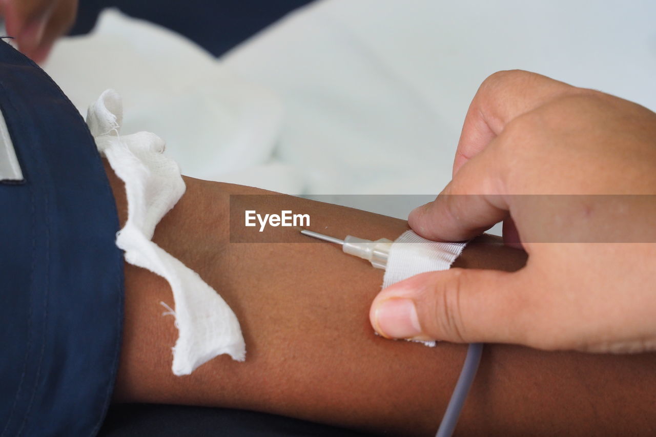 Cropped image of doctor and patient at blood bank