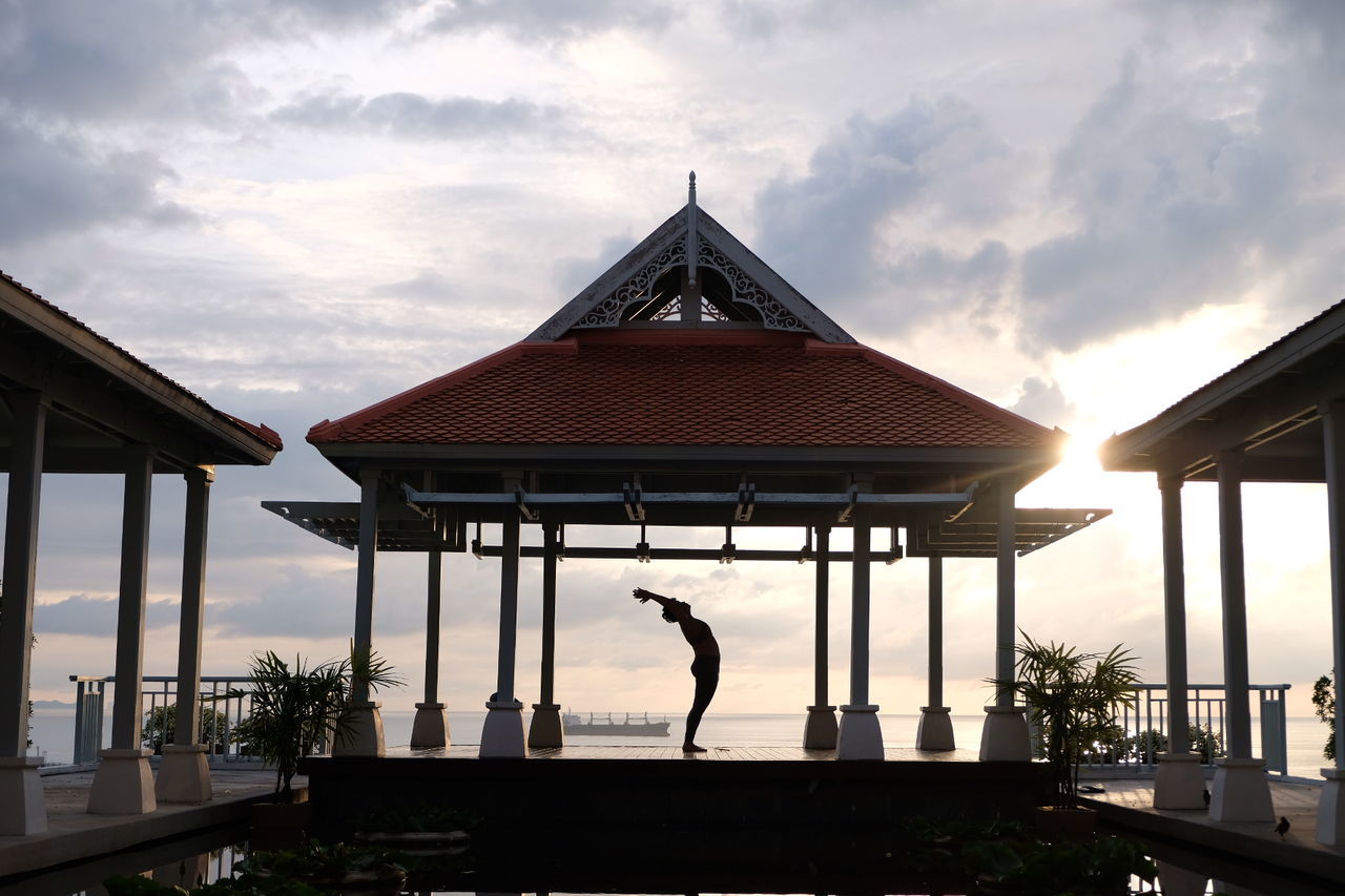SILHOUETTE MAN BY WATER AGAINST SKY