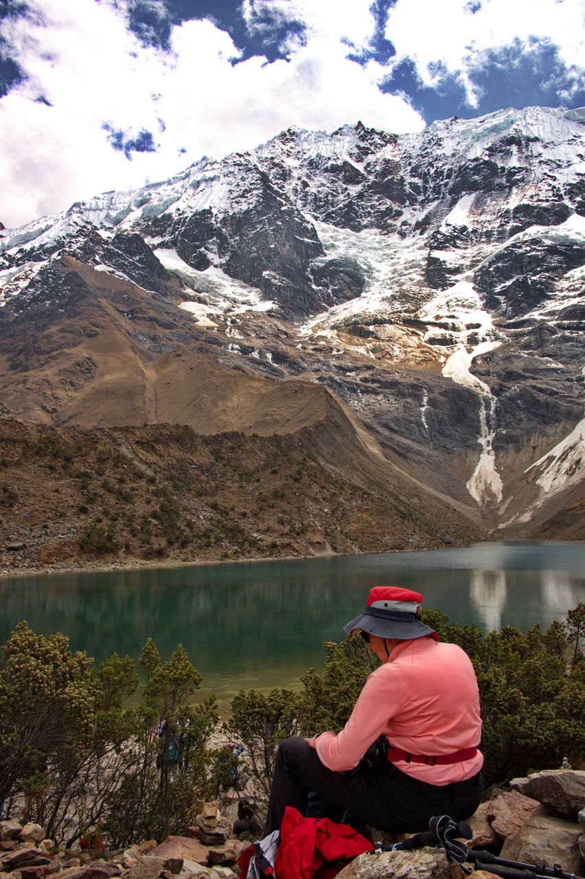 Rear view of senior woman sitting on humantay lake in peru