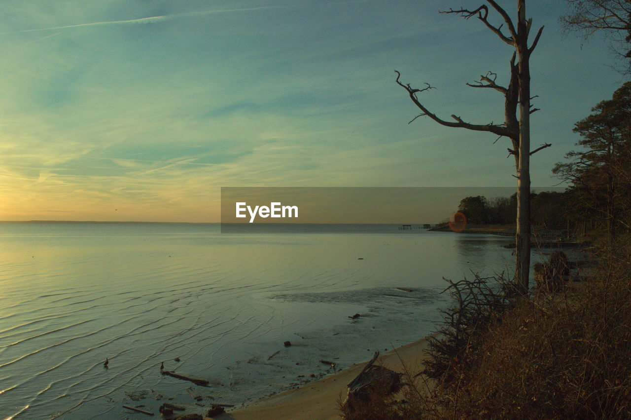 SCENIC VIEW OF BEACH AGAINST SKY AT SUNSET