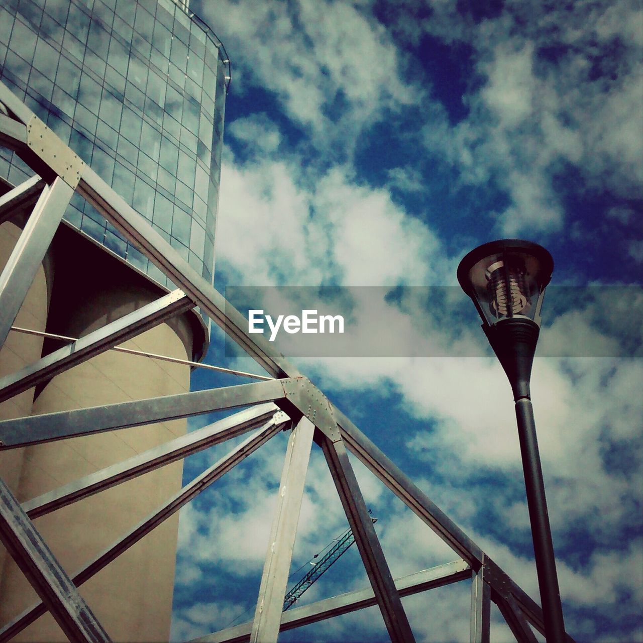 Low angle view of street light by building against sky