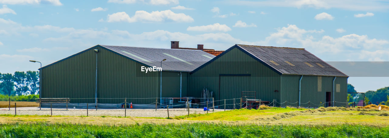 BARN ON FIELD AGAINST BUILDINGS