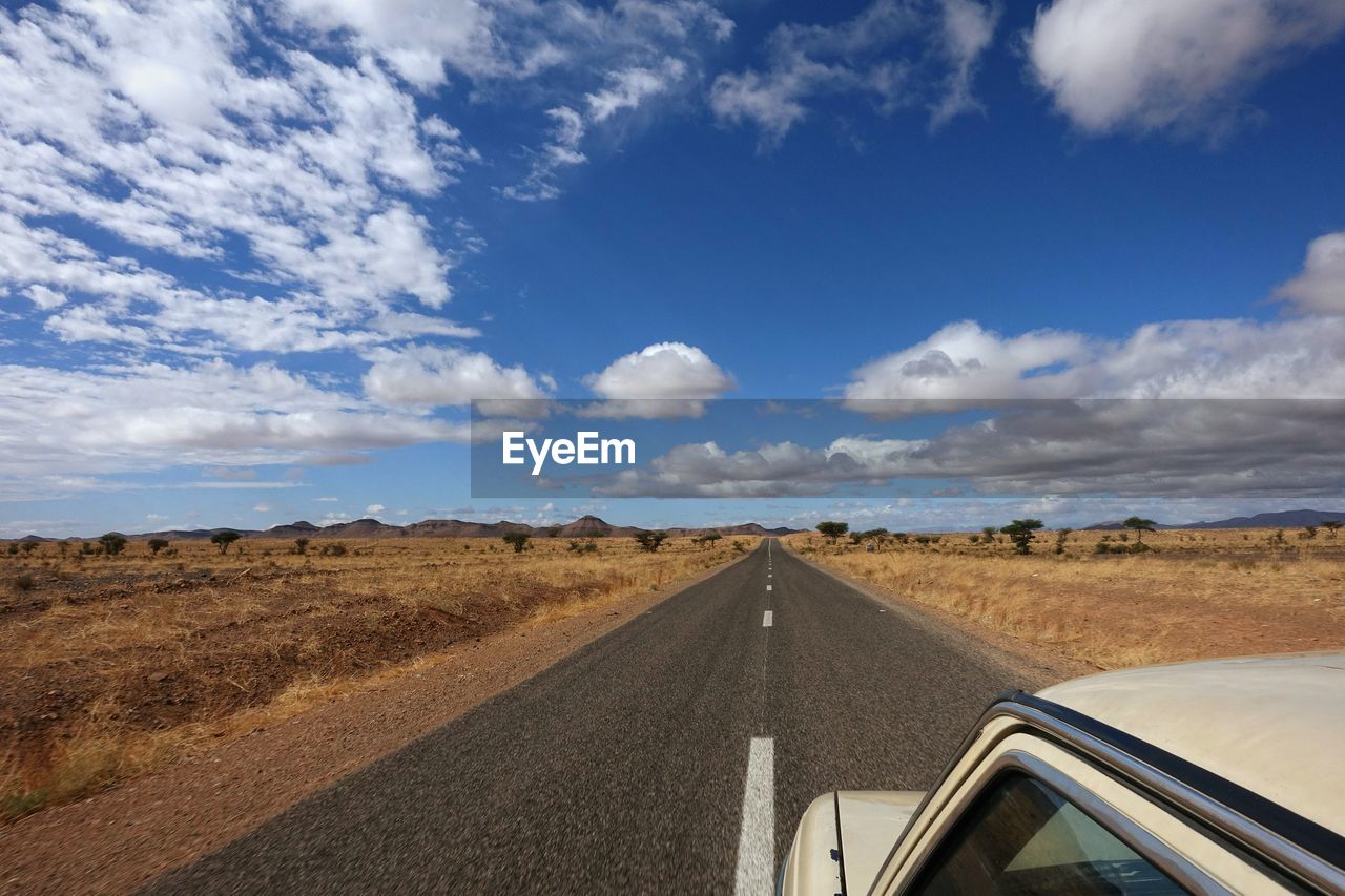 Cropped image of car on road against sky