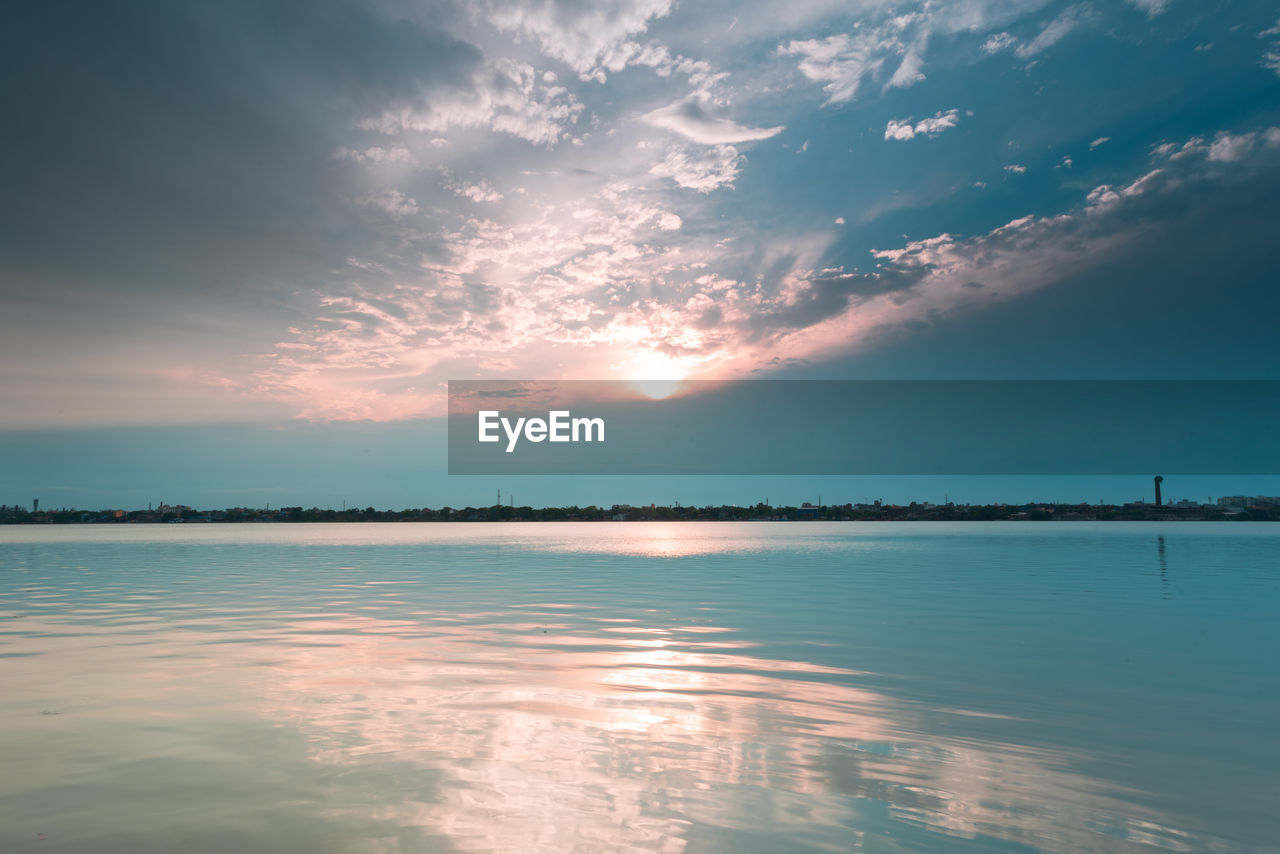 Scenic view of river against sky during sunset