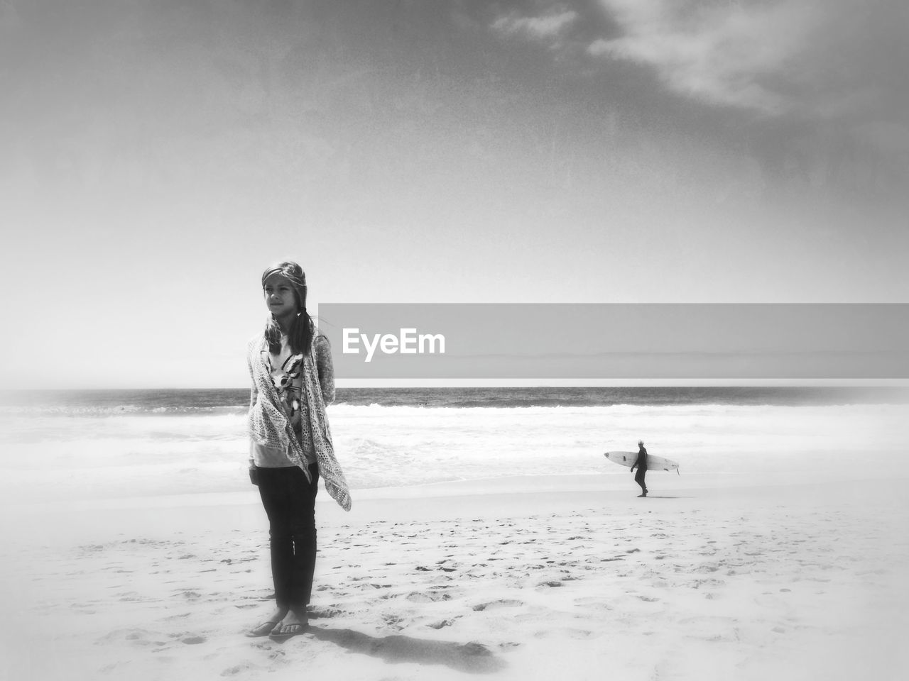 Full length of girl standing on sandy beach against sky