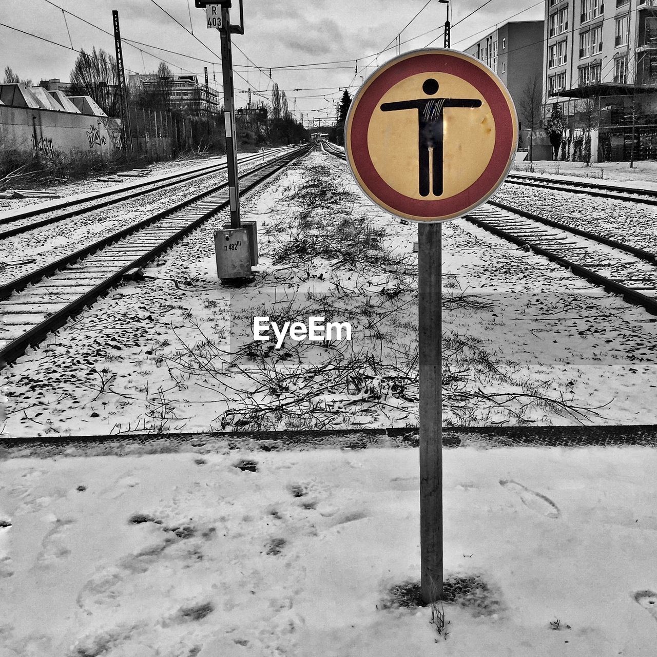 Road sign on snow covered railroad station