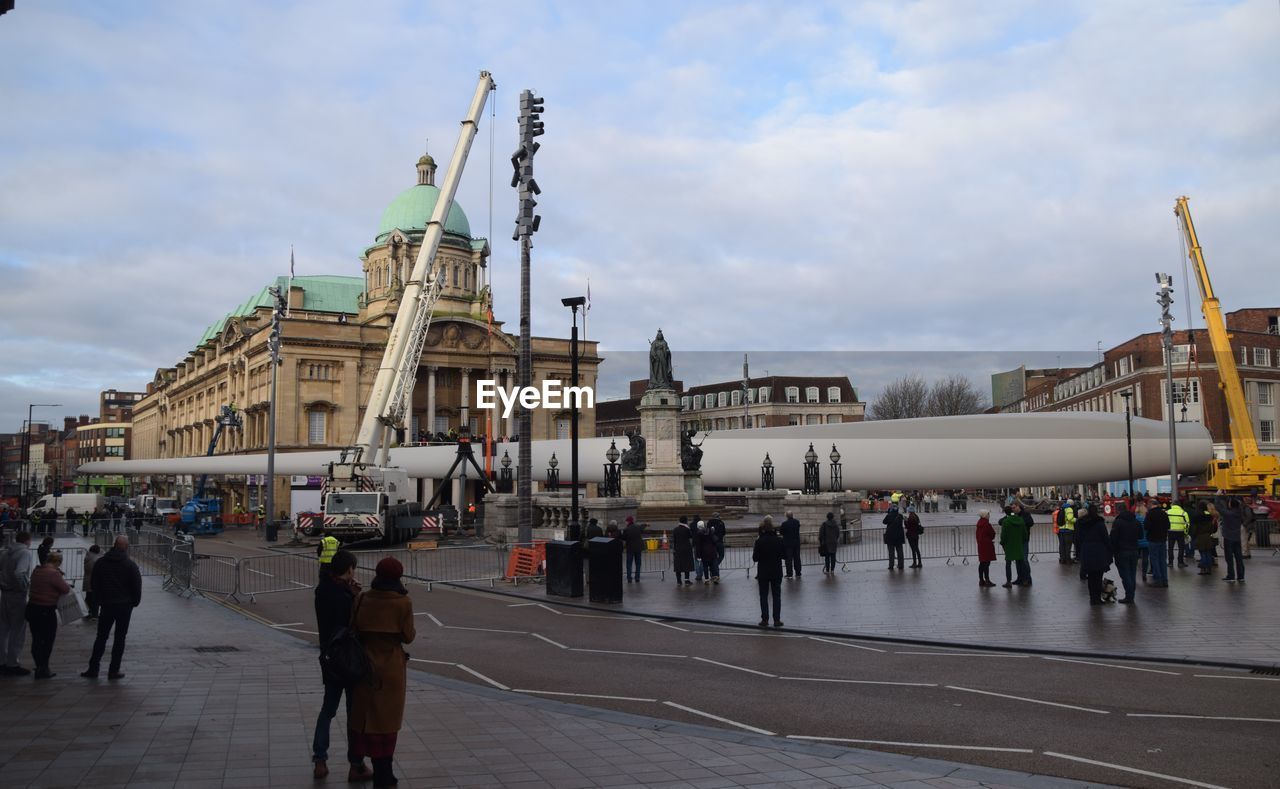 PEOPLE IN FRONT OF BUILDING AGAINST SKY