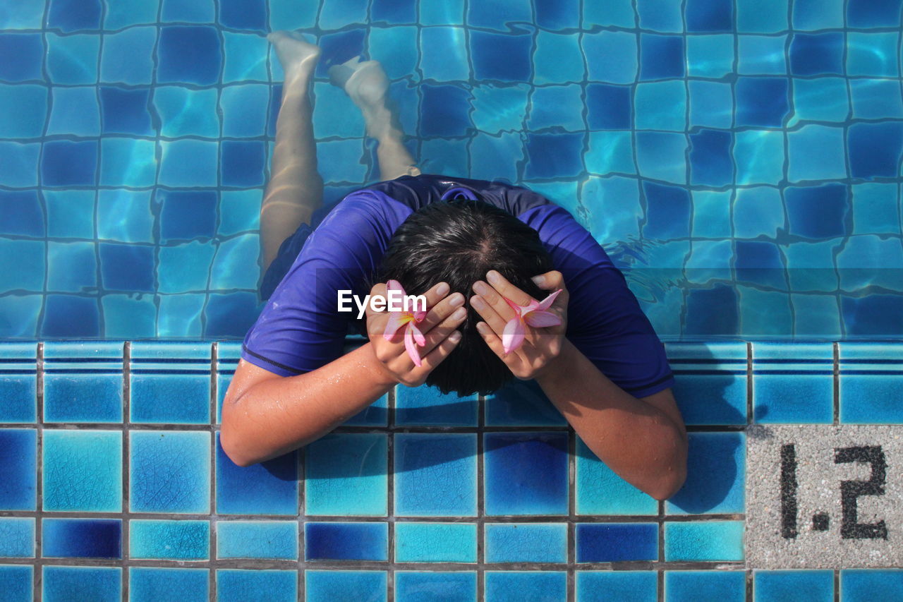 Man in swimming pool with head in hands