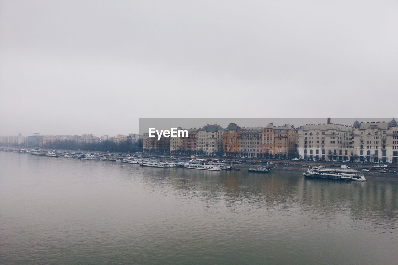 River and buildings against clear sky