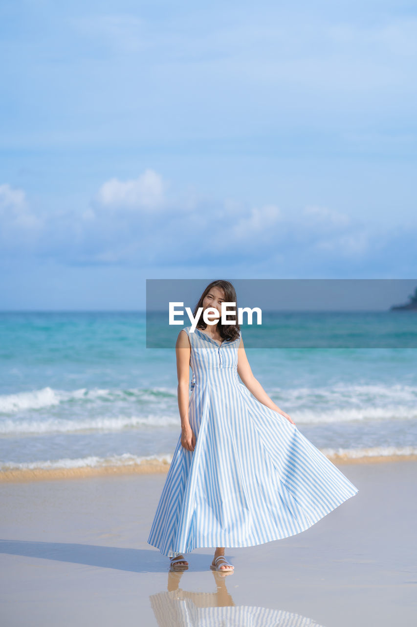 Full length of woman on beach against sky