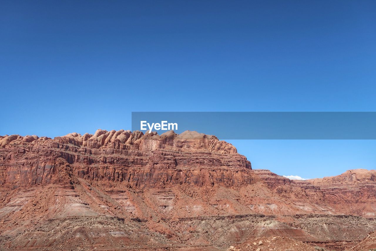 Rock formations in desert against clear blue sky