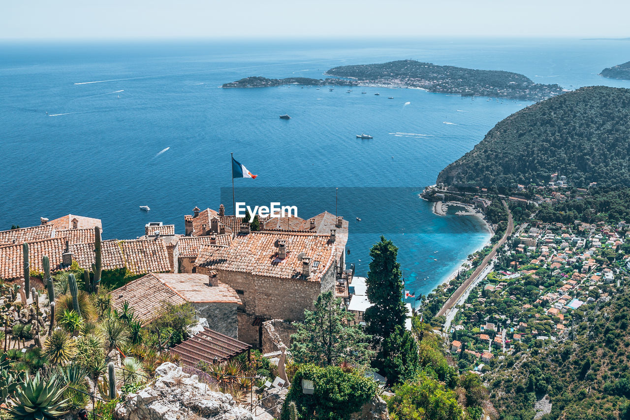 Aerial view of sea by city against sky