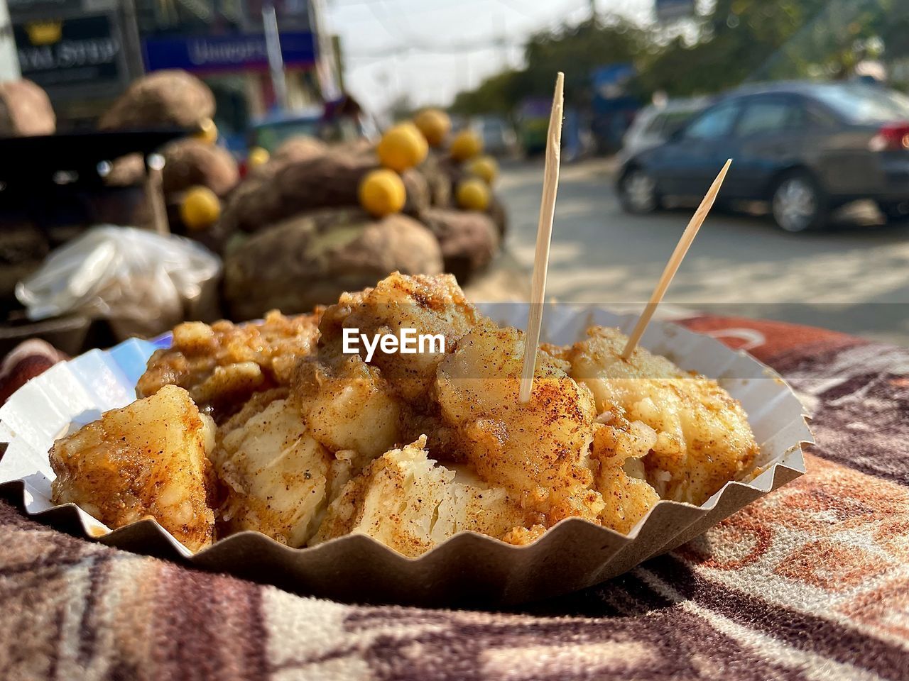 Sweet potato vegetable fruit salad in plate on street cart table with street background view 