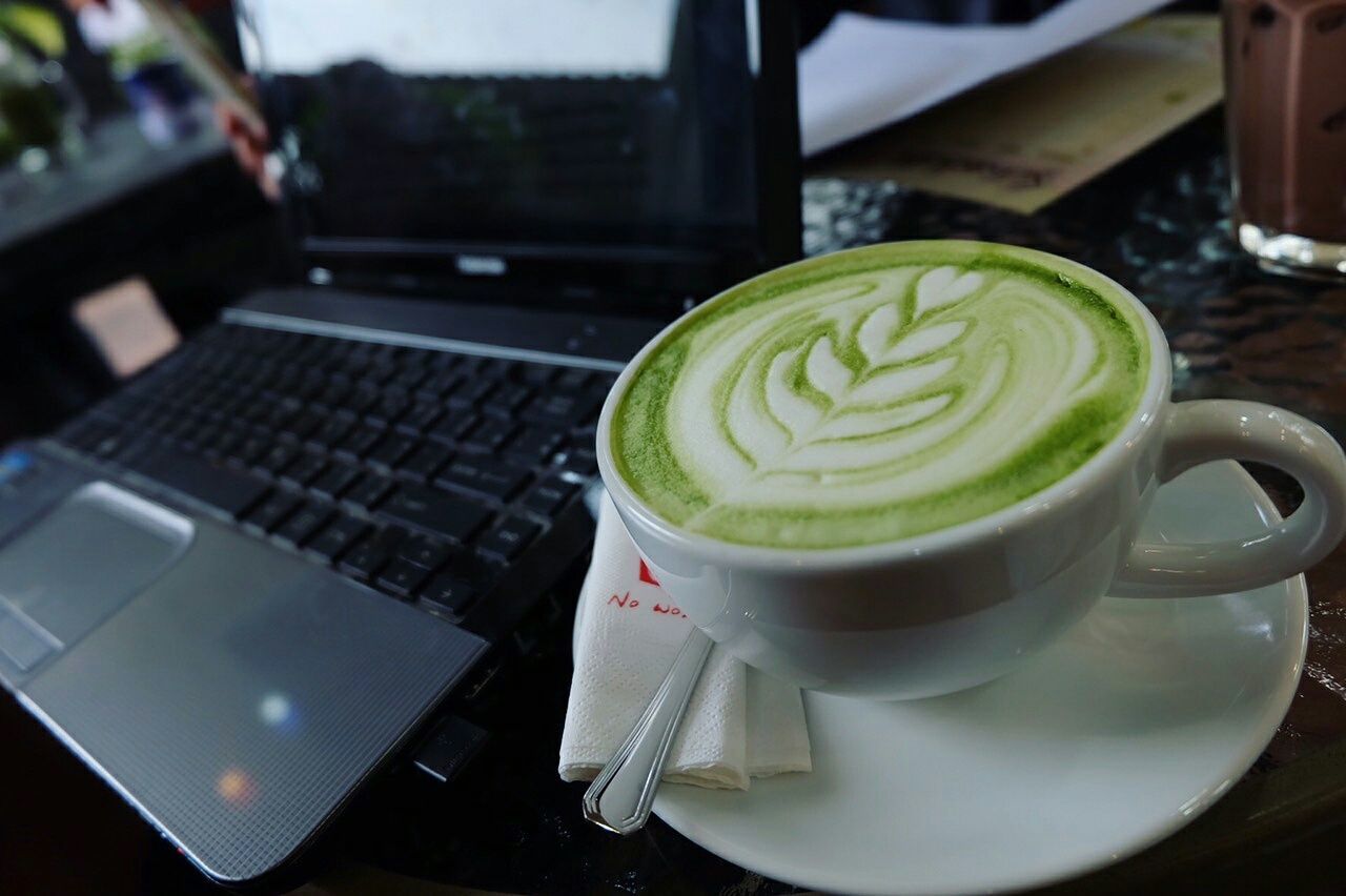 Close-up of coffee by laptop on table