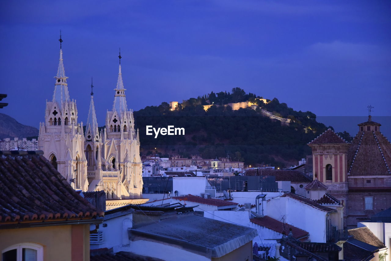 View of buildings in city against blue sky