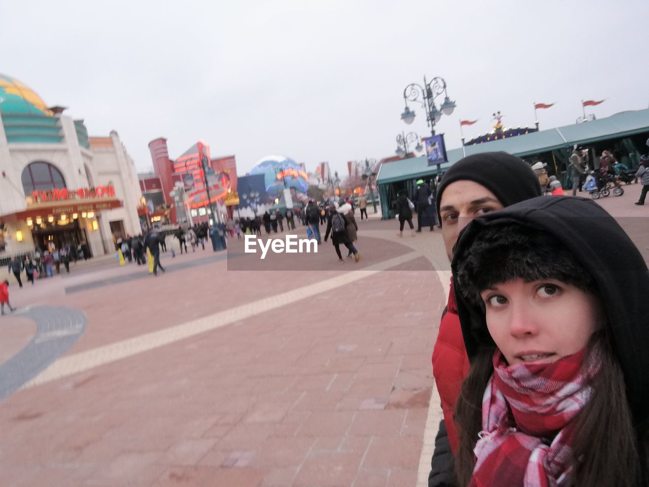 Couple at town square in city against sky