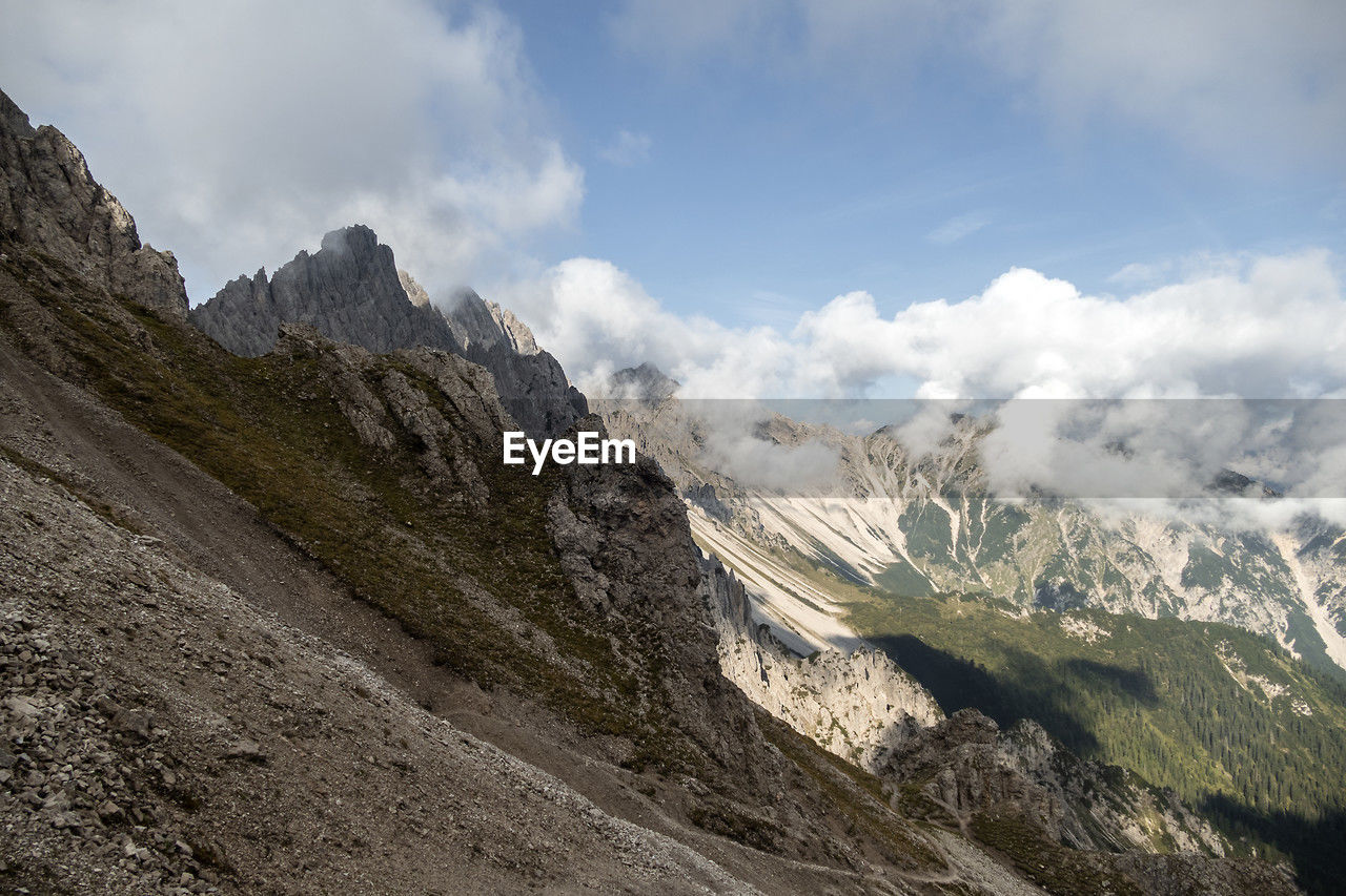 mountain, cloud, environment, sky, scenics - nature, landscape, nature, mountain range, beauty in nature, land, travel, travel destinations, wilderness, mountain pass, adventure, activity, ridge, no people, rock, snow, valley, panoramic, outdoors, mountain peak, leisure activity, non-urban scene, tourism, walking, cold temperature, day, tranquility, tranquil scene, pinaceae, plateau, pine tree, coniferous tree, extreme terrain, cloudscape, winter, backpacking, plant, summit, snowcapped mountain, vacation, trip, holiday