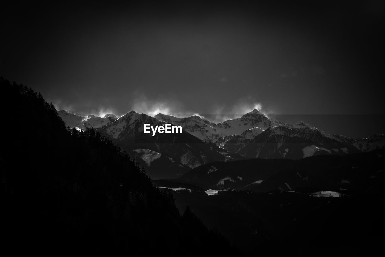 Scenic view of snowcapped mountains against sky at night