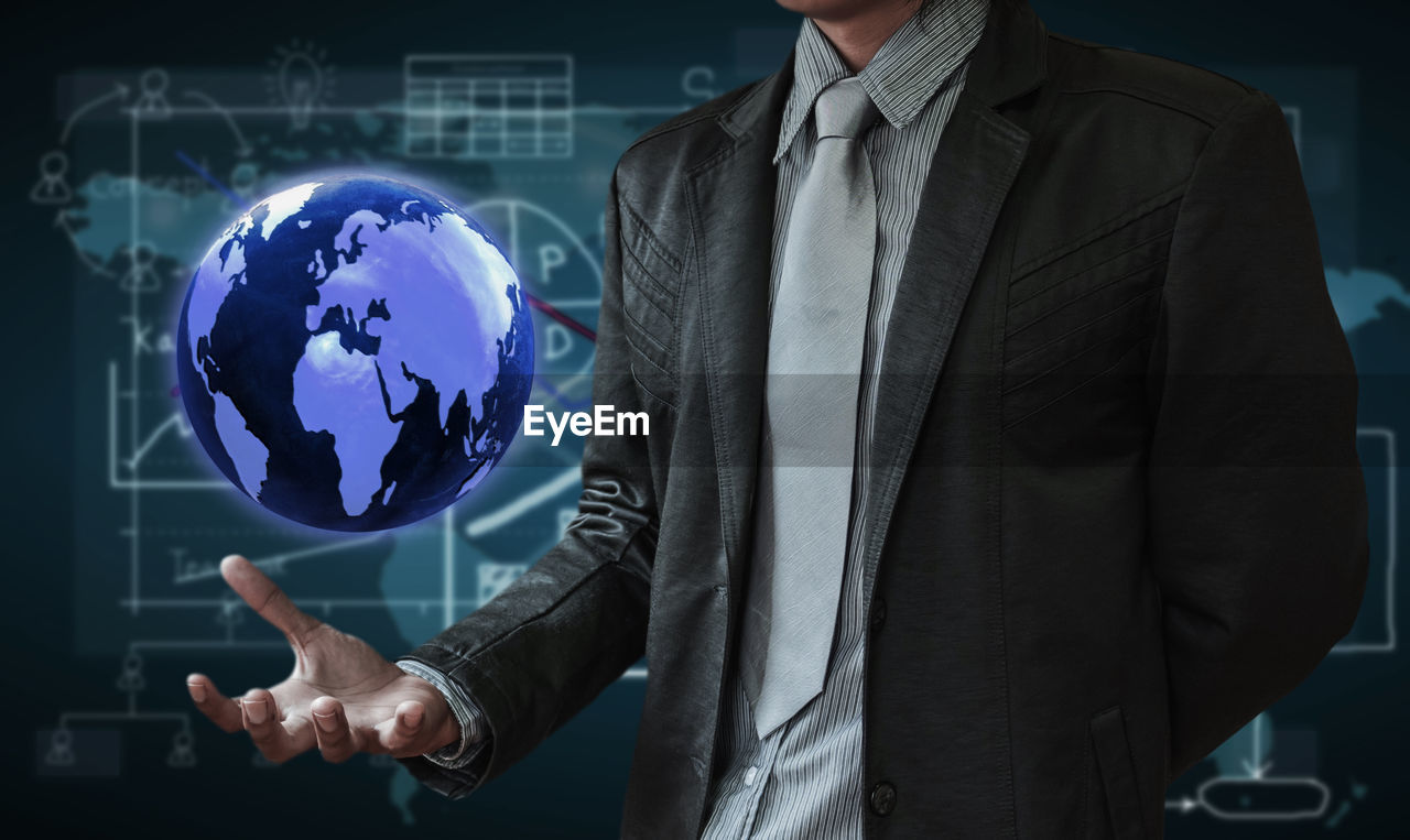 Midsection of man levitating globe against chart