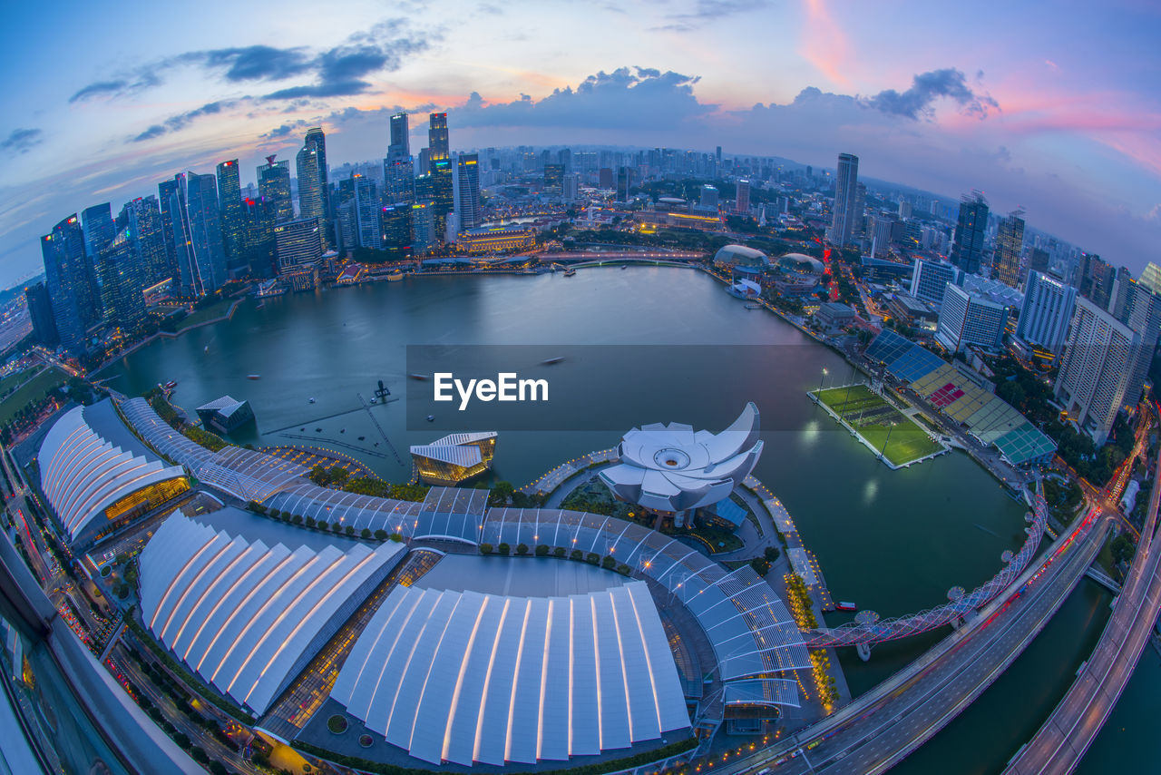 High angle view of city buildings against cloudy sky