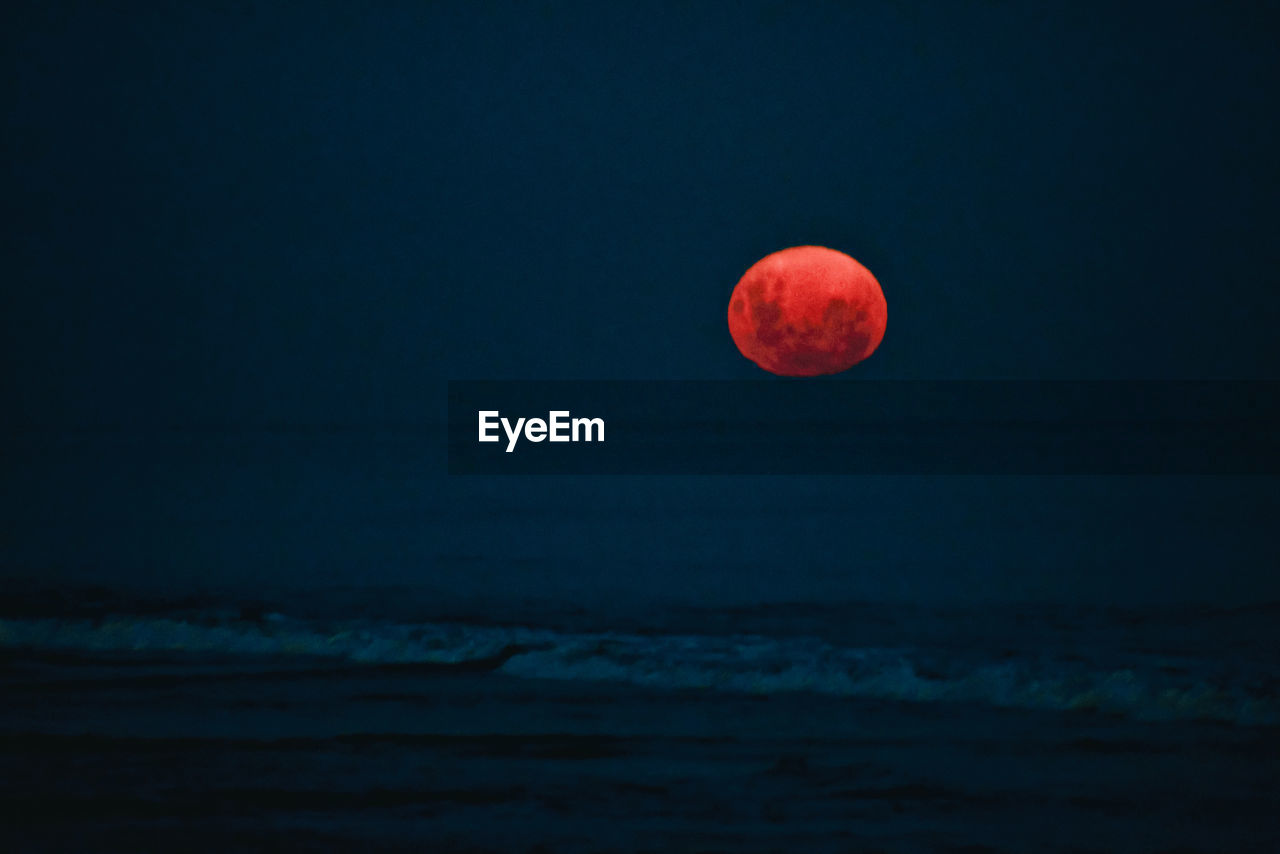 View of sea against moon at night