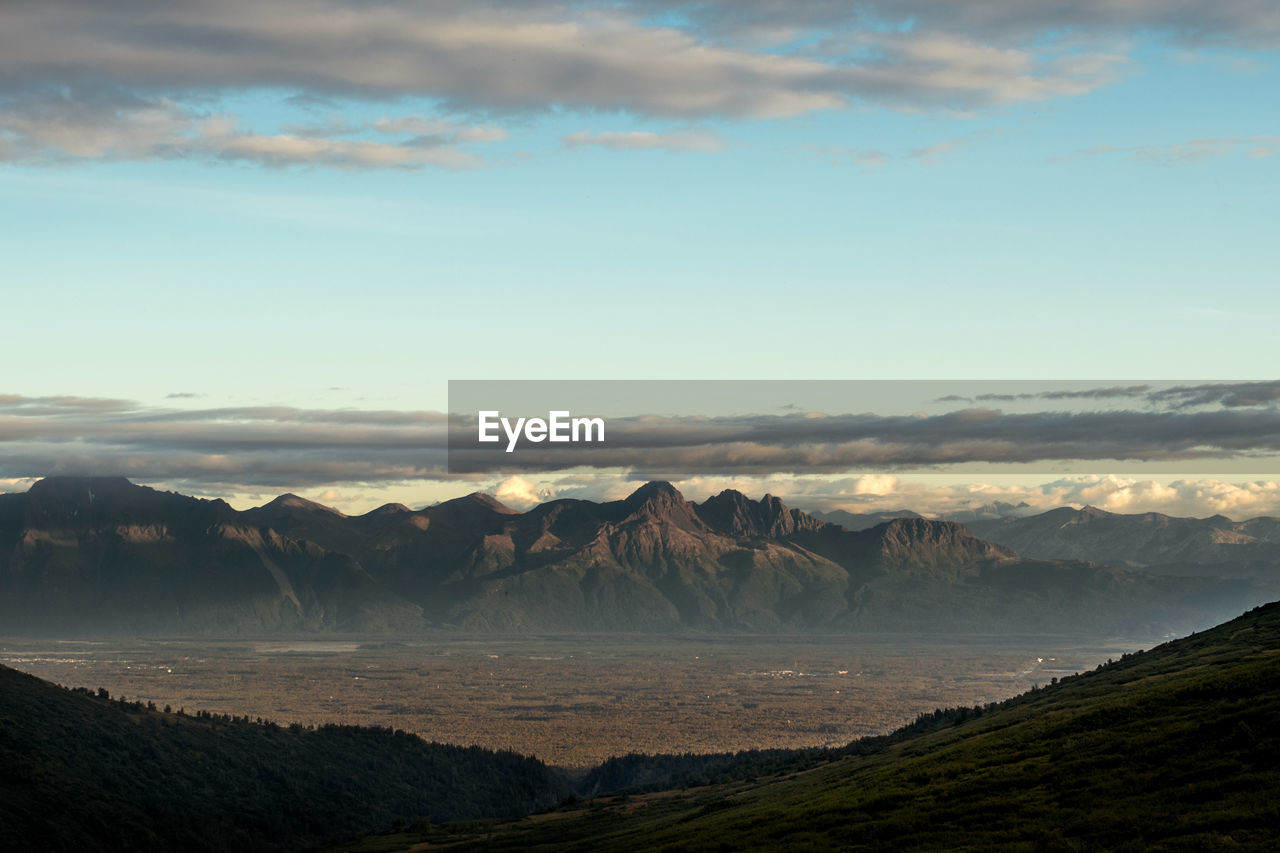 Scenic view of sea and mountains against sky