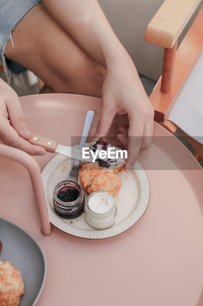 HIGH ANGLE VIEW OF HANDS HOLDING CAKE