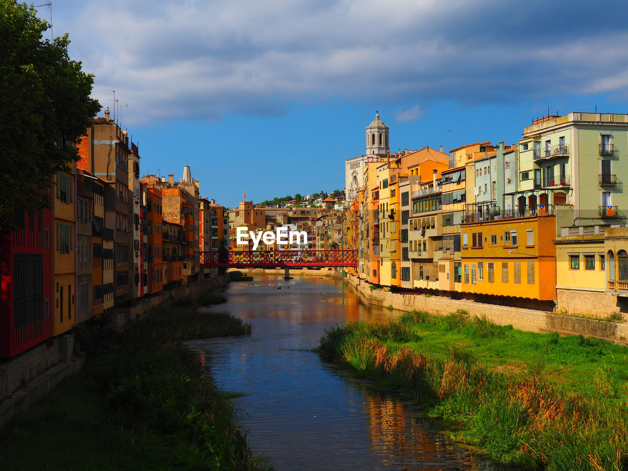 Canal amidst houses against sky in city