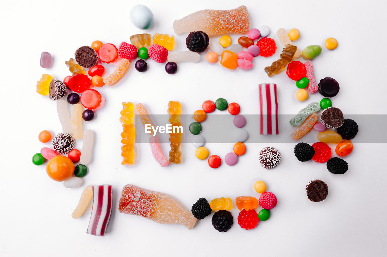 Text made with multi colored candies on white background