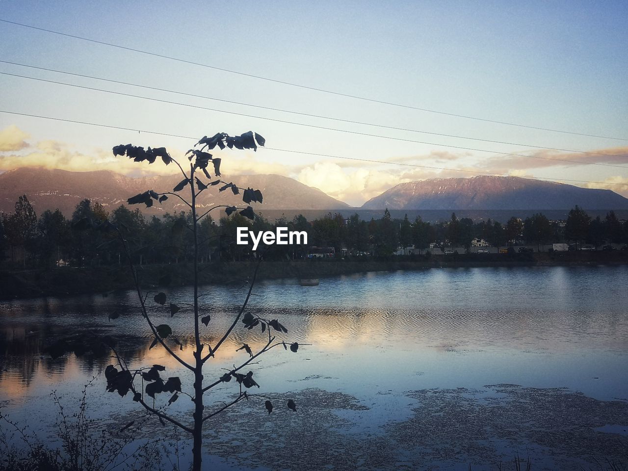 SCENIC VIEW OF LAKE BY SILHOUETTE MOUNTAINS AGAINST SKY