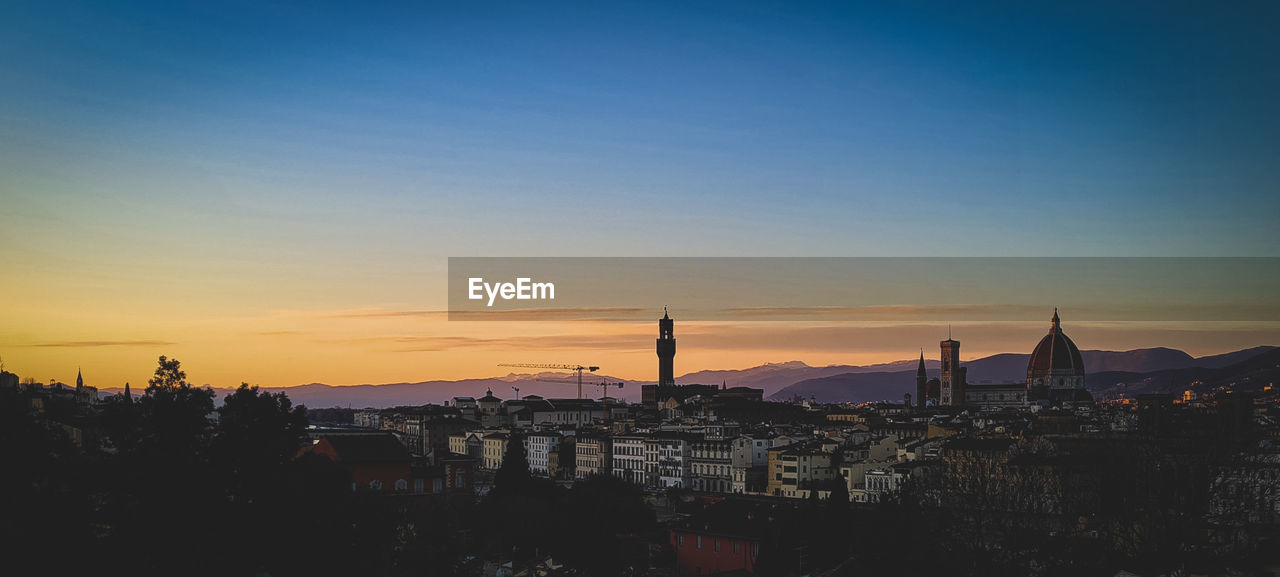 Silhouette of buildings against sky during sunset