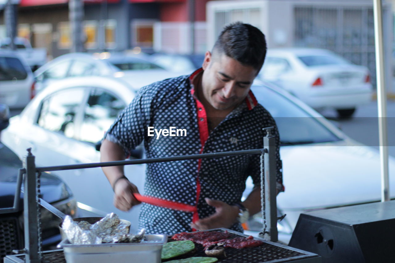 MID ADULT MAN STANDING AT CAR