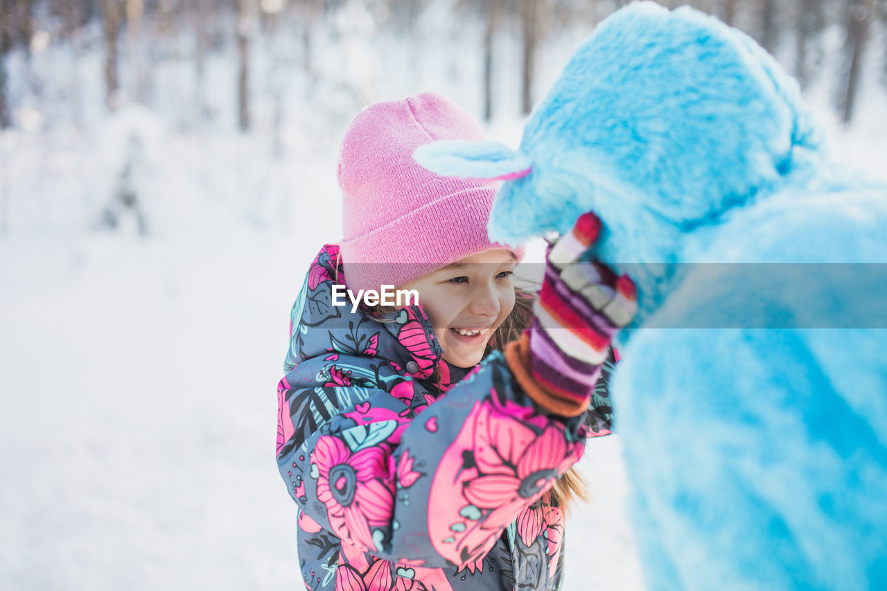 Father wearing costume with daughter on snowy field