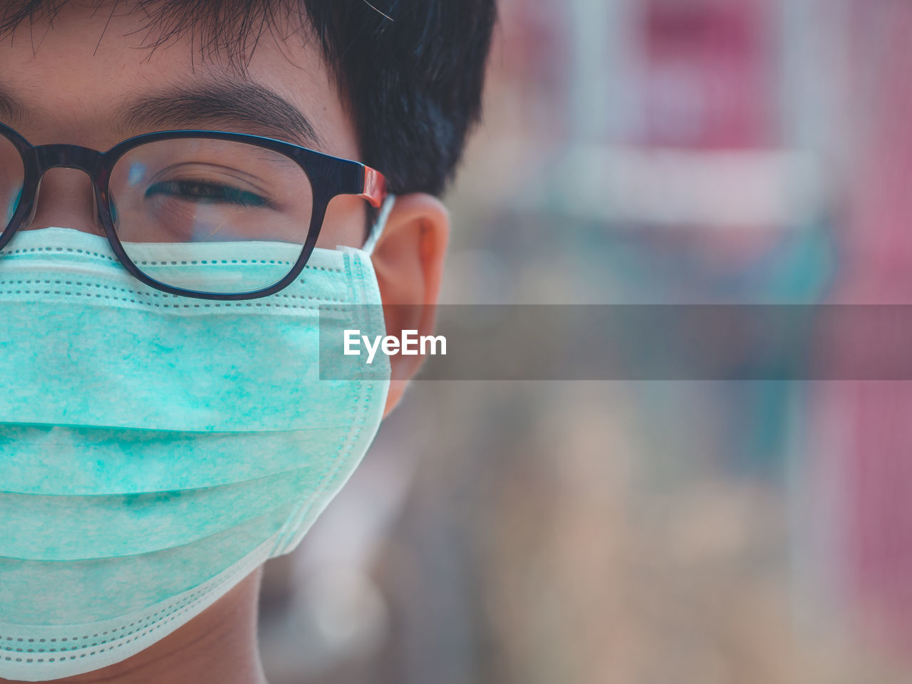 Close-up portrait of boy wearing pollution mask in city