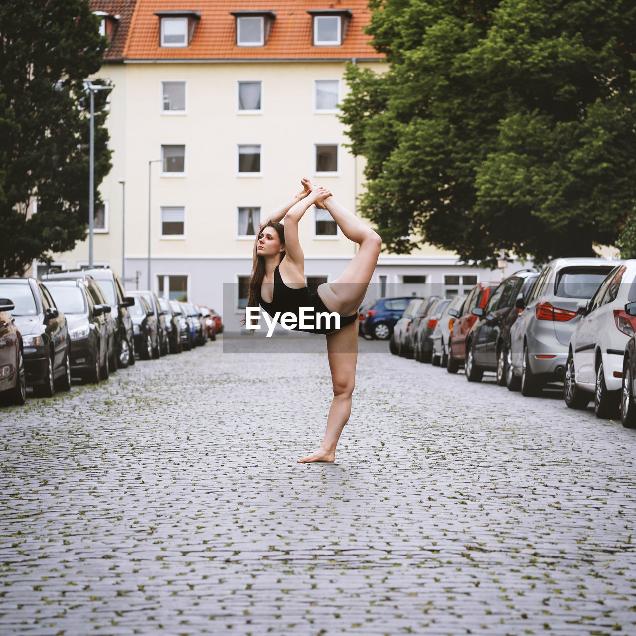 Young woman dancing while standing on footpath