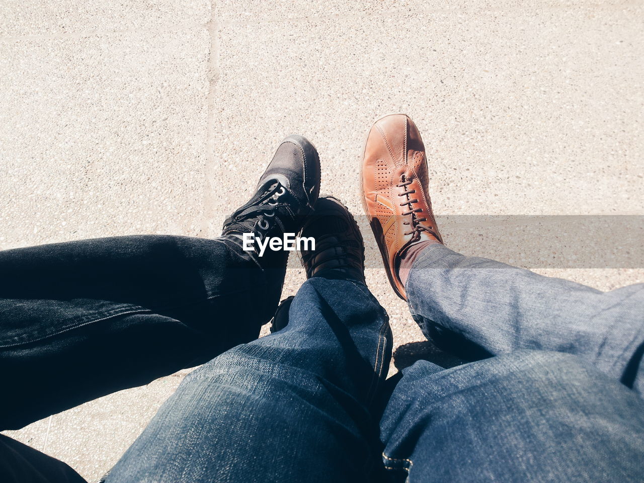 LOW SECTION OF MAN SITTING ON SHOES