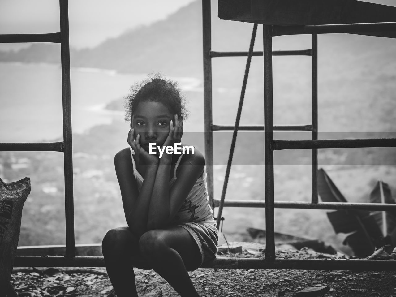 PORTRAIT OF GIRL SITTING ON RAILING