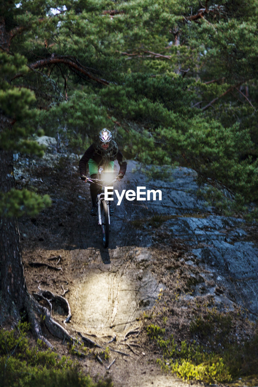 Man cycling through forest