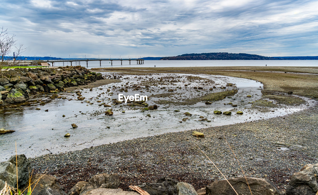 shore, water, coast, sea, sky, land, nature, environment, cloud, beach, landscape, scenics - nature, body of water, beauty in nature, ocean, no people, tranquility, rock, wetland, travel, travel destinations, day, outdoors, tranquil scene, coastline, plant, tourism, sand, reflection, low tide, wave, non-urban scene, natural environment