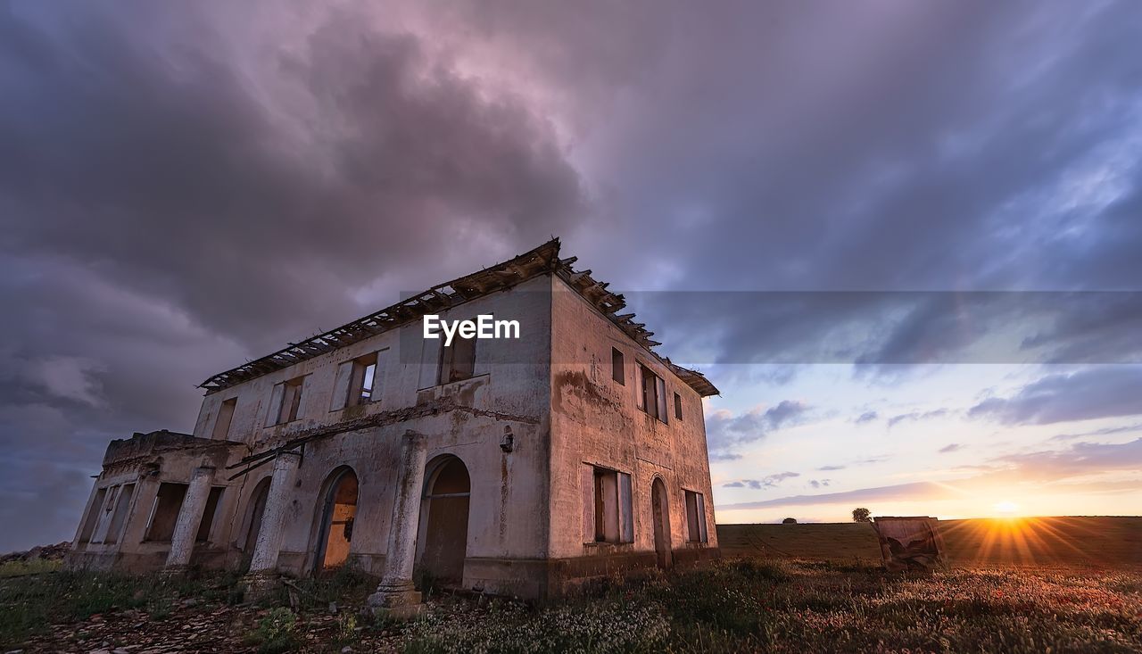 Low angle view of old building against sky during sunset