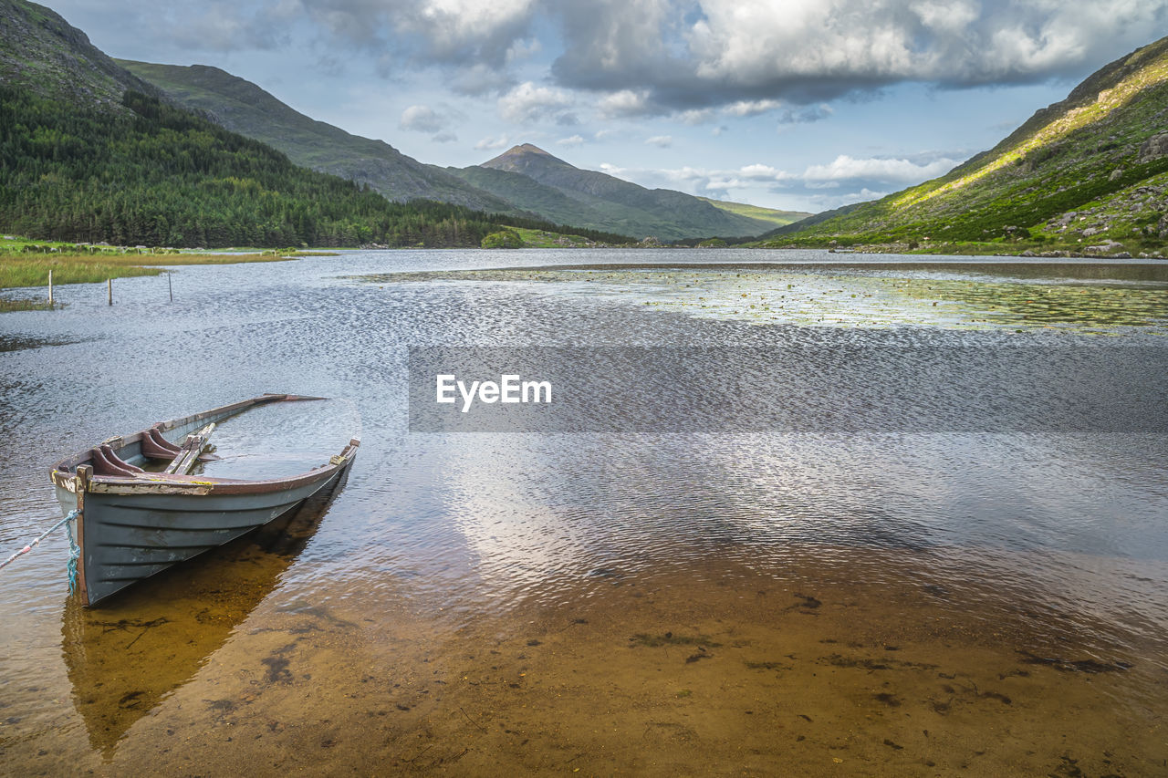 Sunken or submerged paddle boat in lough gummeenduff with view on beautiful black valley, ireland