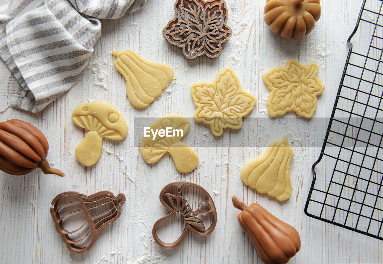 Baking cookies in the form of pumpkin and leaves. cozy autumn pastry. dough with cookie cutters.